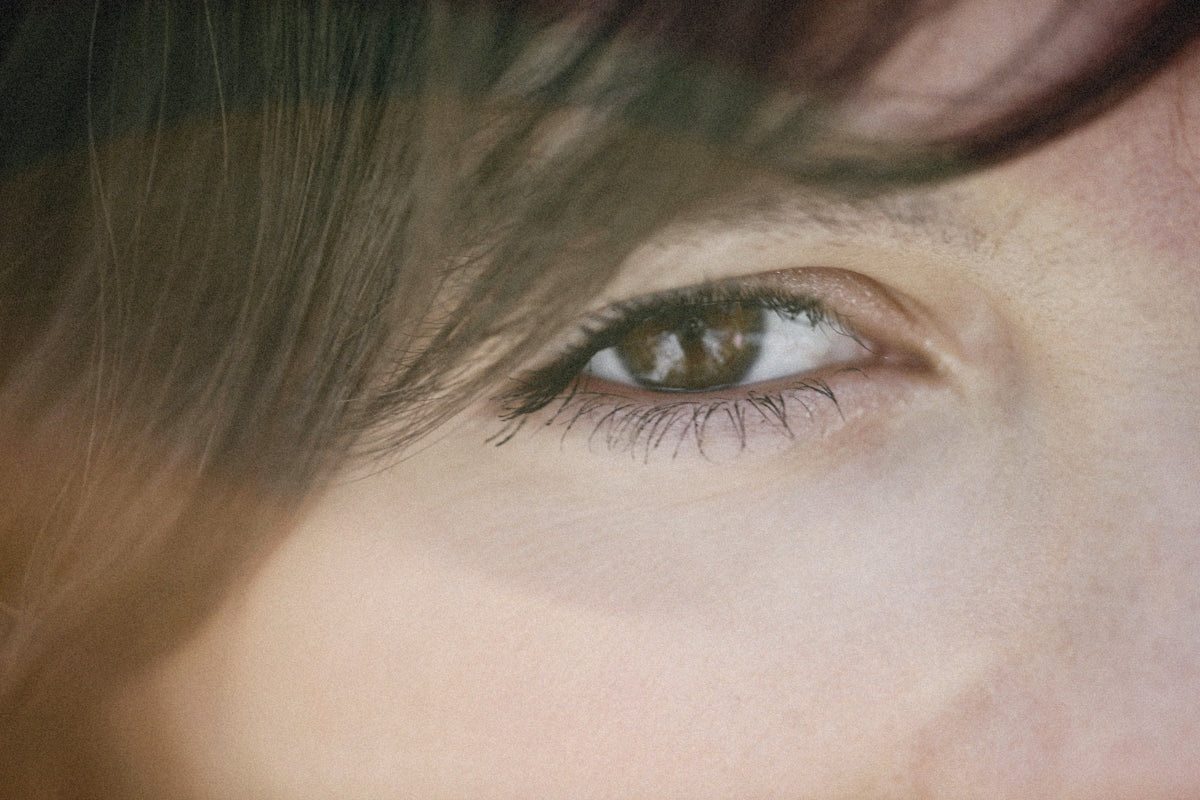 a close up of a person's eye with long hair