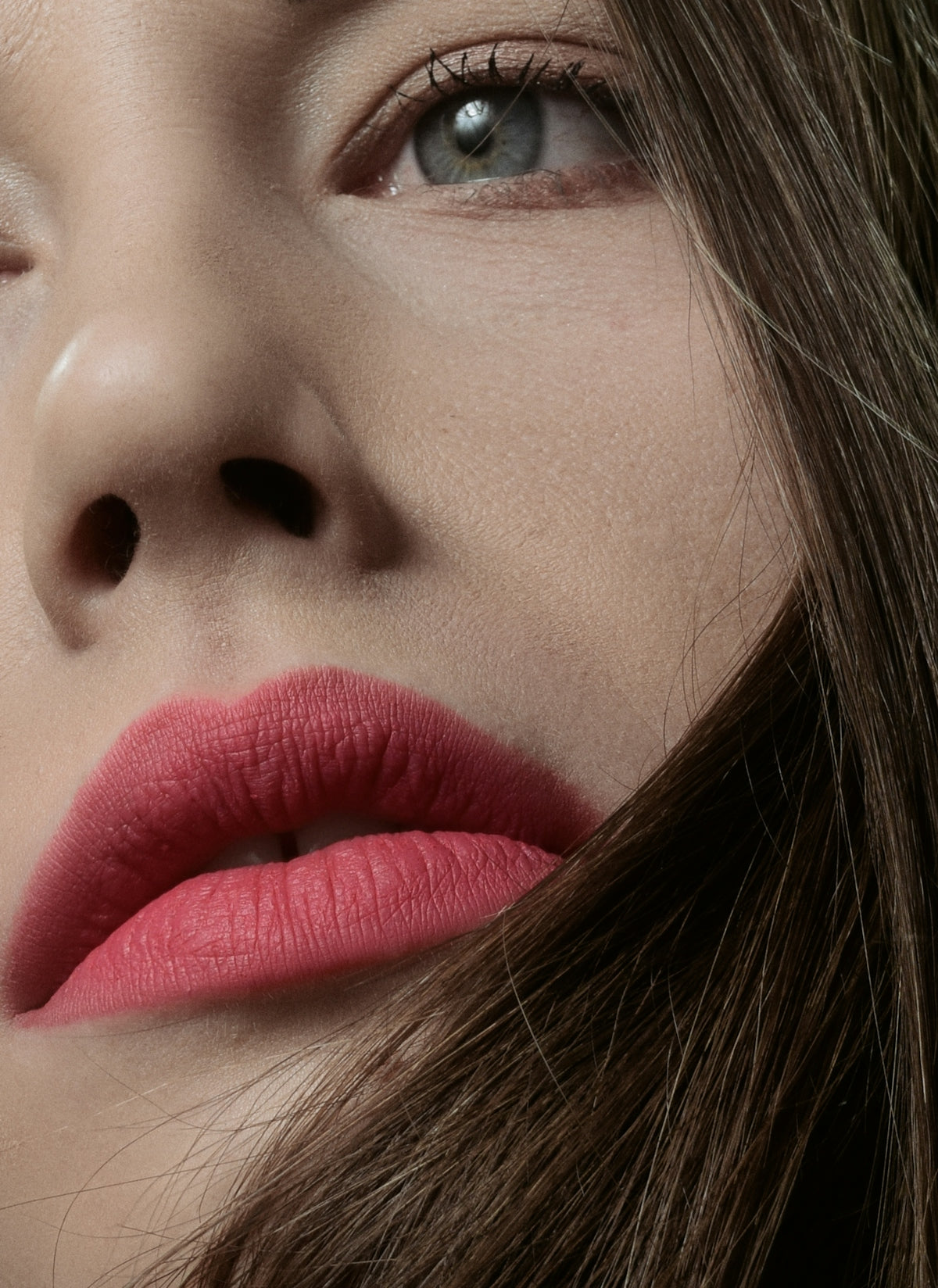 a close up of a woman's face with her hair blowing in the wind