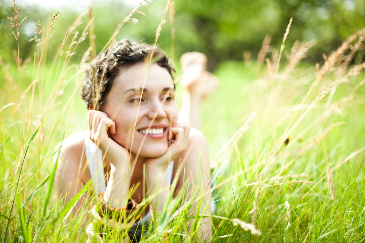 A woman laying in a field of tall grass