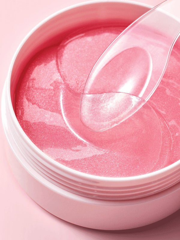 Kenzina eye masks being gently lifted out of a pink jar