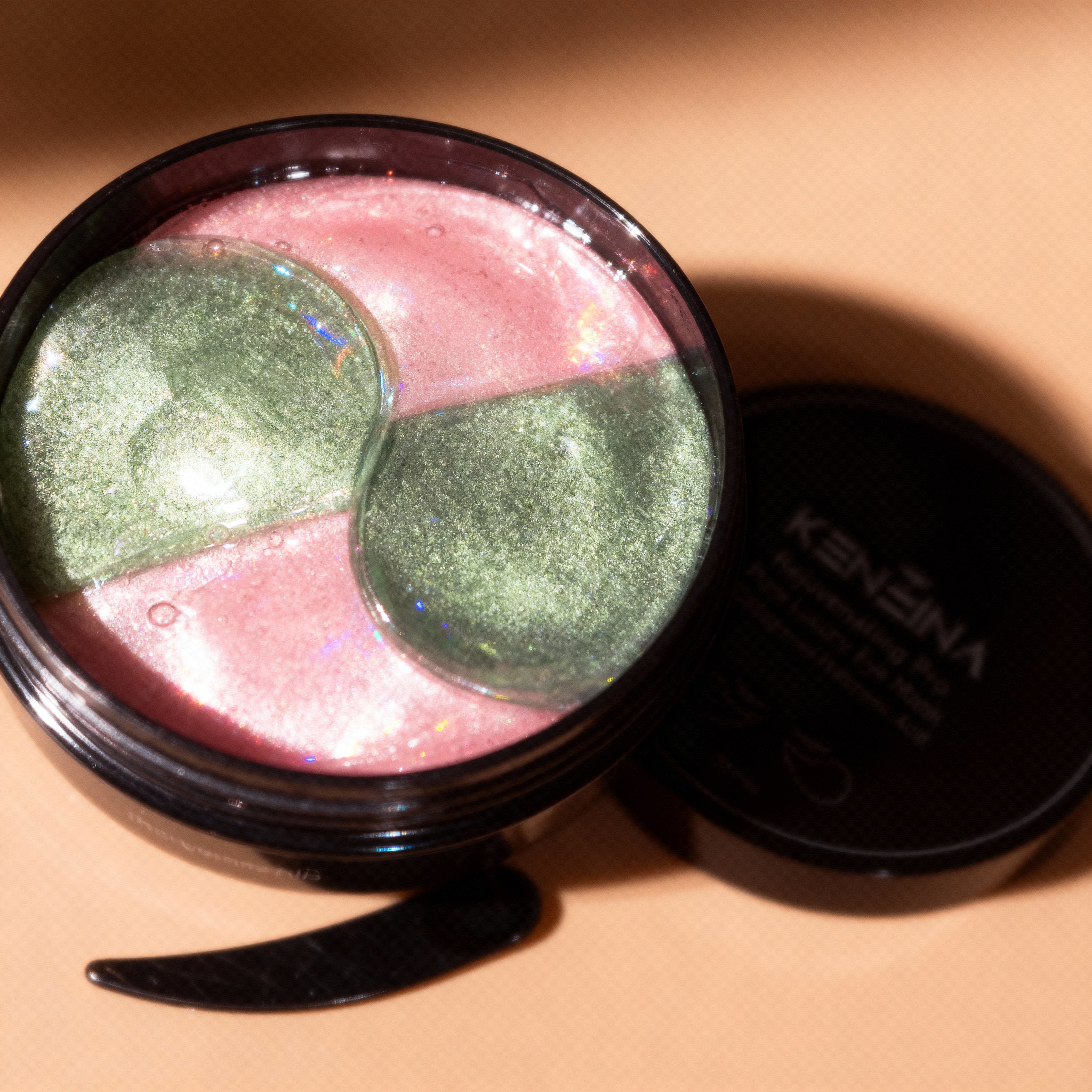 Eye mask product with pink and green shades on a beige background