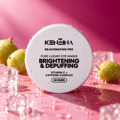 Kenzina Brightening & Depuffing eye masks jar on a glossy pink surface with ice and Kakadu plums
