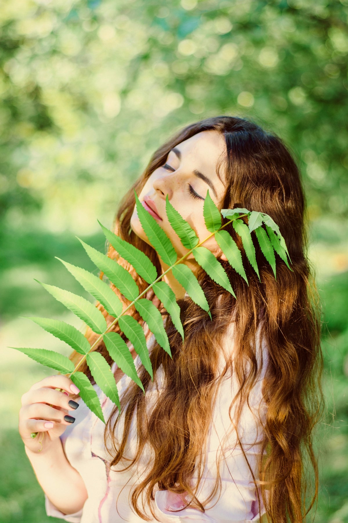 woman holding green leaf during daytime