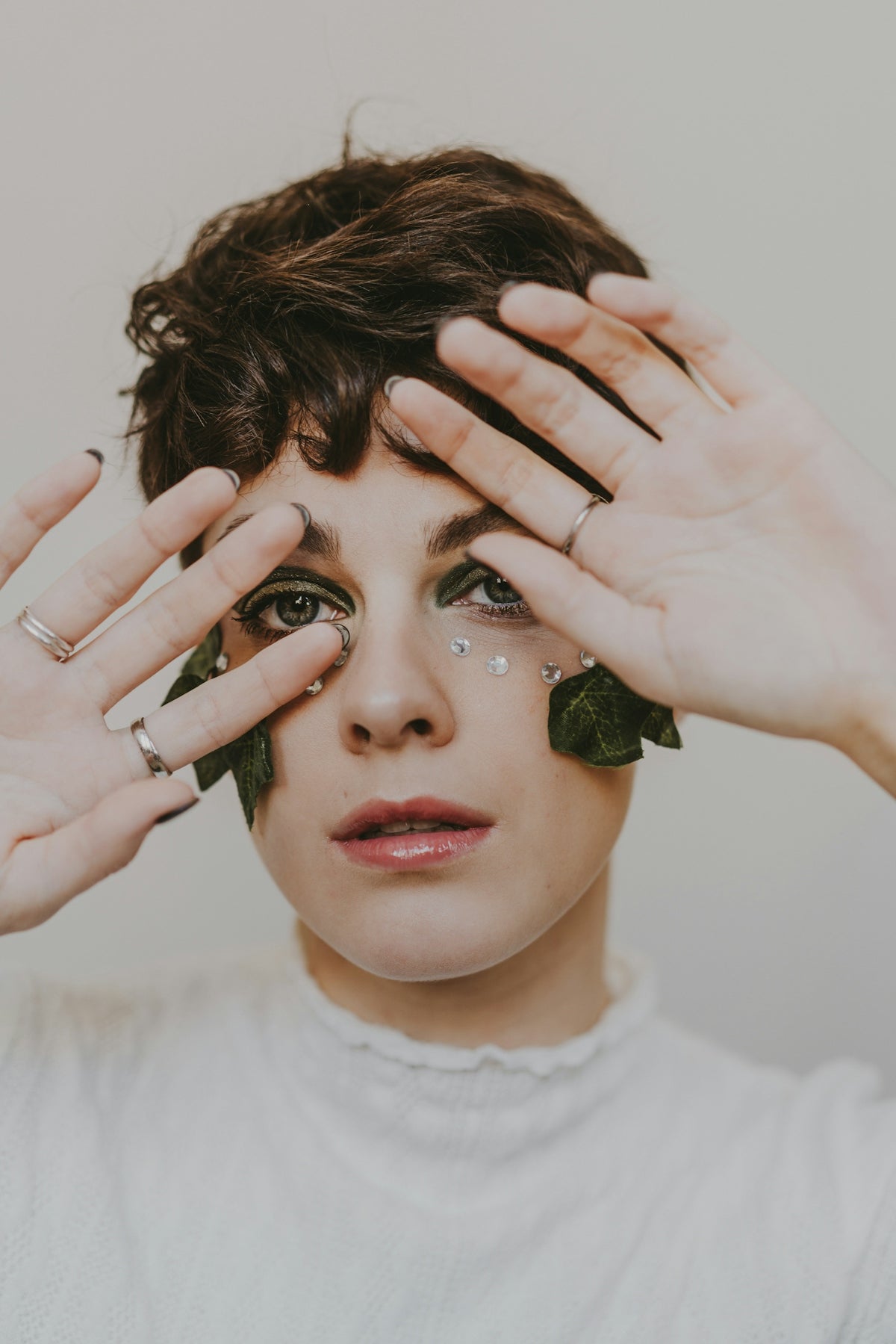 a woman holding her hands up to her face