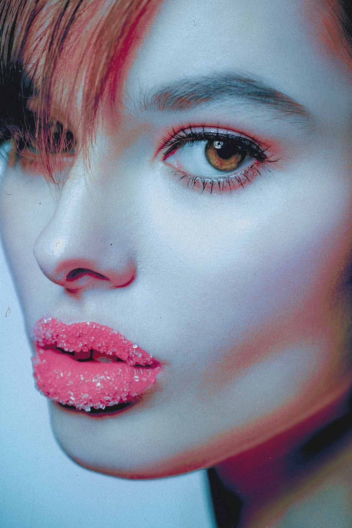 a close up of a woman's face with pink lipstick